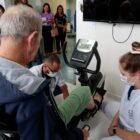 Paciente utiliza bicicleta para reabilitação no tratamento do AVC orientado por uma profissional