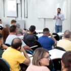 Secretário de educação fala na frente de professores sentados em plateia