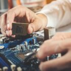 Detalhe da mão de um homem manuseando em equipamento eletrônico