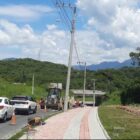 Rua em obras, com máquinas e homens trabalhando