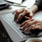 Mão de mulher teclando em notebook