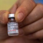 Profissional segura frasco com vacina contra a Covid-19