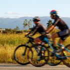 Ciclistas andam de bicicleta com capacetes e roupas especiais