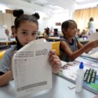 Menina segura papel com check list da dengue