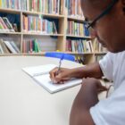 Aluno escreve em caderno