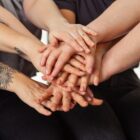 Várias mãos de mulheres, uma em cima da outra