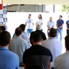 Prefeito discursa em púlpito, ao lado de autoridades, observados por plateia