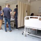 Pessoas em pé em frente de macas de hospital