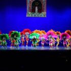 Bailarinos de danças populares se apresentam com figurino em palco