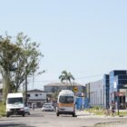 Foto de uma rua com carros passando e uma Vila da Saúde em um dos lados
