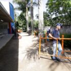 Trabalhadores com capacete seguram estruturas que serão colocadas nos muros das escolas