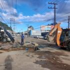 Homens e máquinas trabalham para consertar tubulação rompida em rua