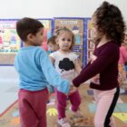 Crianças brincam de roda em sala de CEI