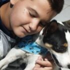 Menino abraça cão