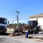 Homem com capacete trabalha em obra, perto de um caminhão