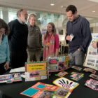 Profissionais em volta de stand com apresentação do material de Joinville