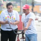 Mulher segura folheto e mostra para ciclista