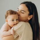 Mãe segura bebê no colo e o beija
