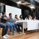 Em palco, atrás de mesa, participantes do seminário