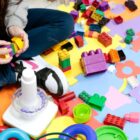 Criança não identificada brinca com peças de brinquedo