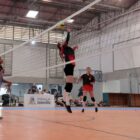 Alunas disputam partida de vôlei em quadra
