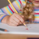 Menina faz desenho em caderno