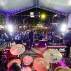 Banda em palco se apresenta para público