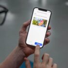 Homem segura celular e acessa o Joinville Fácil
