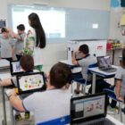 Alunos sentados em sala de aula desenvolvendo atividades nos computadores