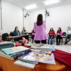 Palestrante de costas fala com pessoas sentadas em cadeira