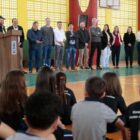 Prefeito Adriano discursa em púlpito observado por autoridades e alunos