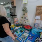 Mulher observa exposição de projeto feito em escola exposto no hall da prefeitura