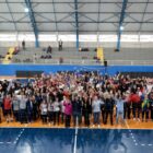Atletas e integrantes do governo tiram foto juntos em quadra esportiva