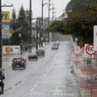 Rua com placas de trânsito e carros e motos trafegando