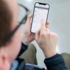 Homem com óculos utiliza celular no aplicativo Joinville Fácil