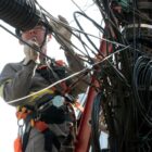 Trabalhador realizando o serviço de remoção de fios no poste