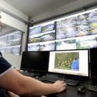 Técnico da Defesa Civil avalia imagens em sala cheia de telas com câmeras