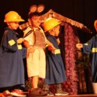 Crianças com fantasias apresentam teatro no palco