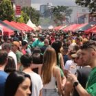 Pessoas reunidas em rua com barracas durante Stammtisch