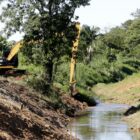 Máquina trabalha na limpeza de área perto de rio