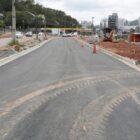 Rua, em obras, com cones de sinalização e asfalto novo