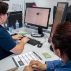 Servidora atende cidadã e digita no teclado do computador