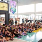 Secretário de educação fala para alunos sentados em quadra