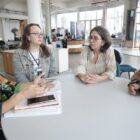 Quatro mulheres sentadas à mesa, em reunião