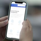 Mulher segura celular na página da transparência aberta