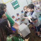 Alunos olham trabalhos expostos em feira de matemática