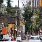 Homens com uniformes e capacetes retiram fios sem utilização com apoio de escadas e equipamento de segurança