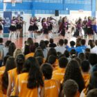 Grupo apresenta coreografia enquanto plateia observada sentada na nova quadra