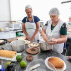 Mulheres preparam alimentos em cozinha