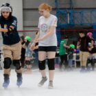Monitor acompanha criança patinando
